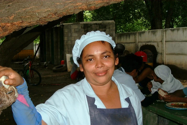 a lady holding up a plate of food at an outdoor market