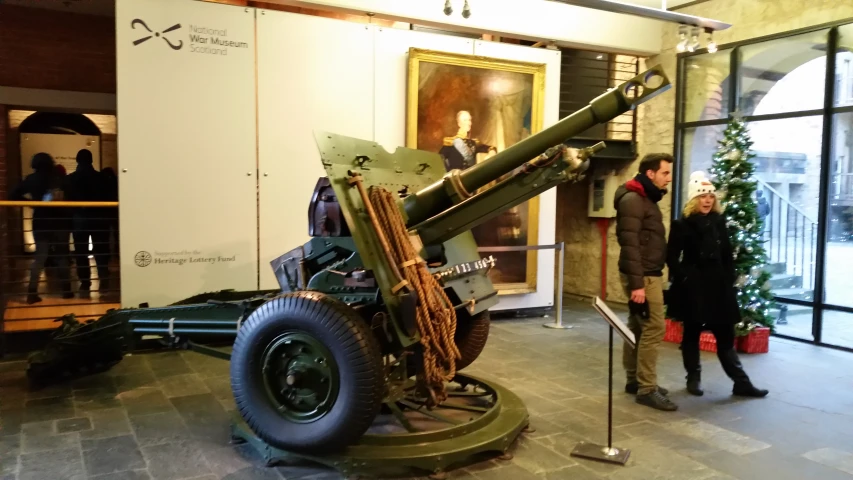 two men stand in front of a very old looking cannon