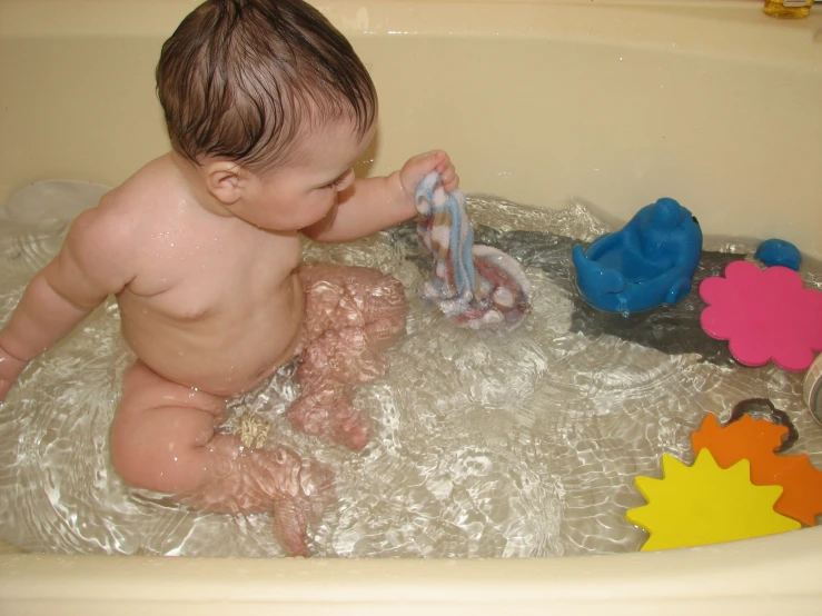 a young child in the tub playing with toys