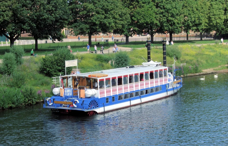 a boat is on the river, near the park