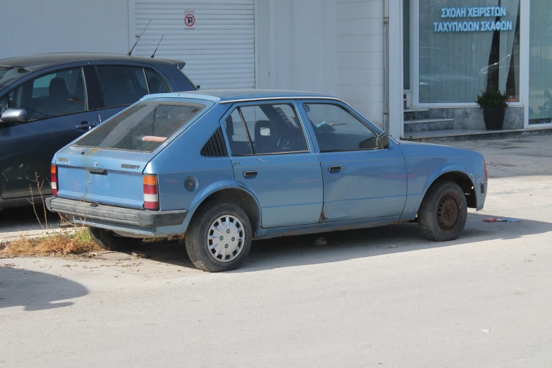 a blue car parked next to another black car