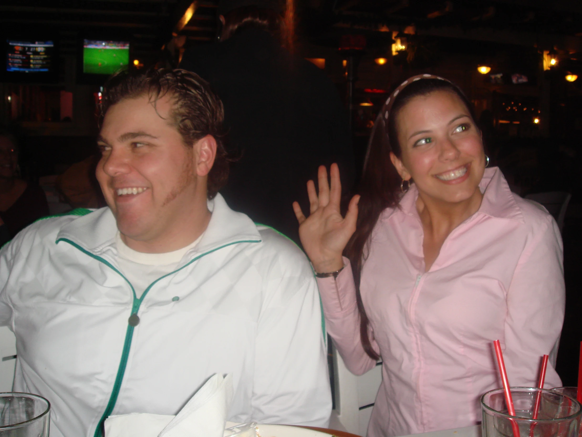 a man standing next to a woman in a bar