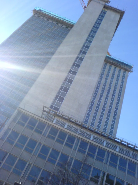 an older, multi - story building in the city with tall buildings against the clear blue sky