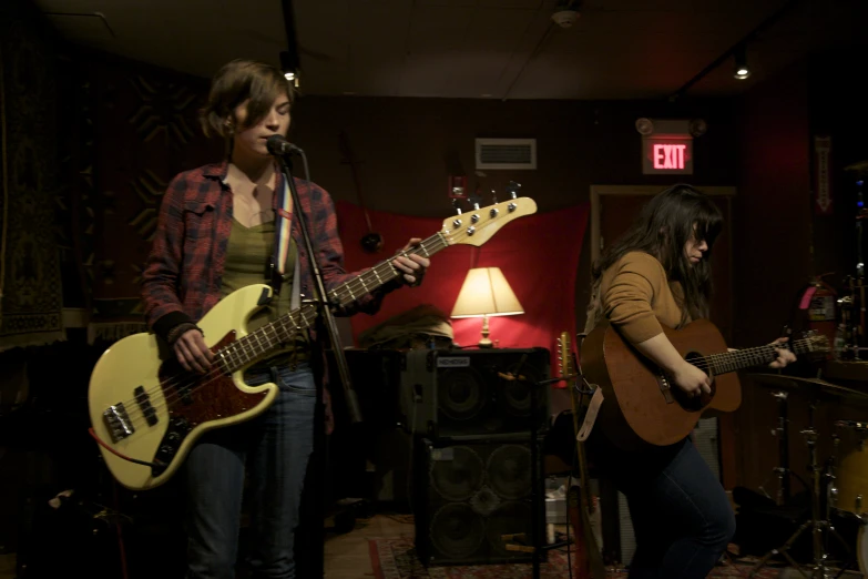 a couple of people are playing guitars in the dark