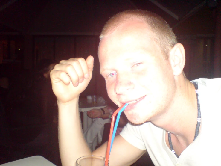 a man drinking water with a straw in his mouth