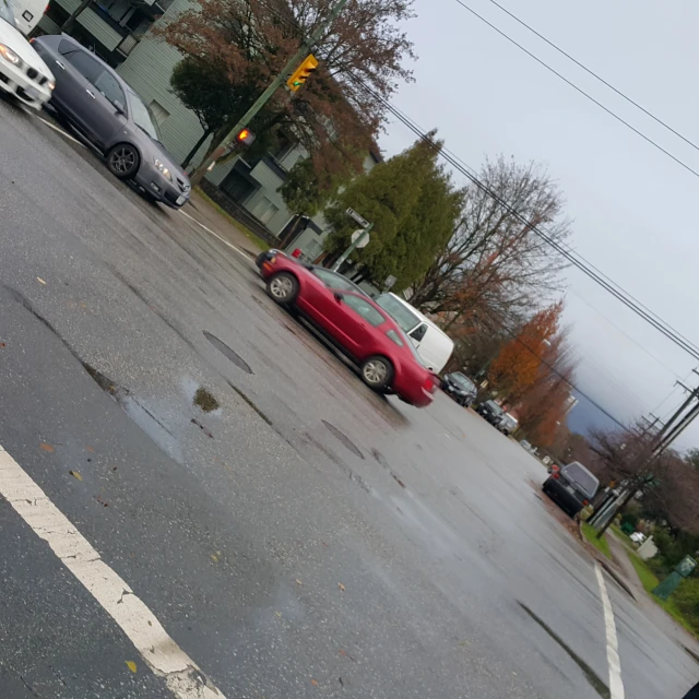 some cars driving down the street by a stop light