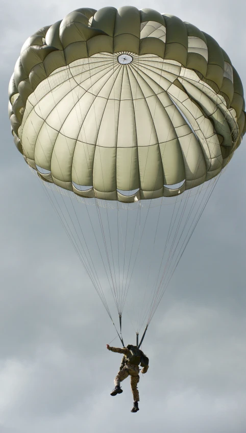 a man with a parachute being lifted by a large airplane