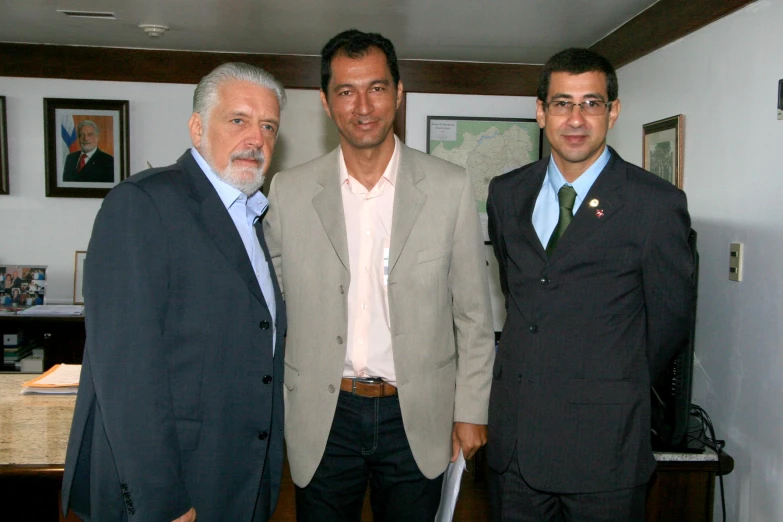 three men are standing next to each other in suits