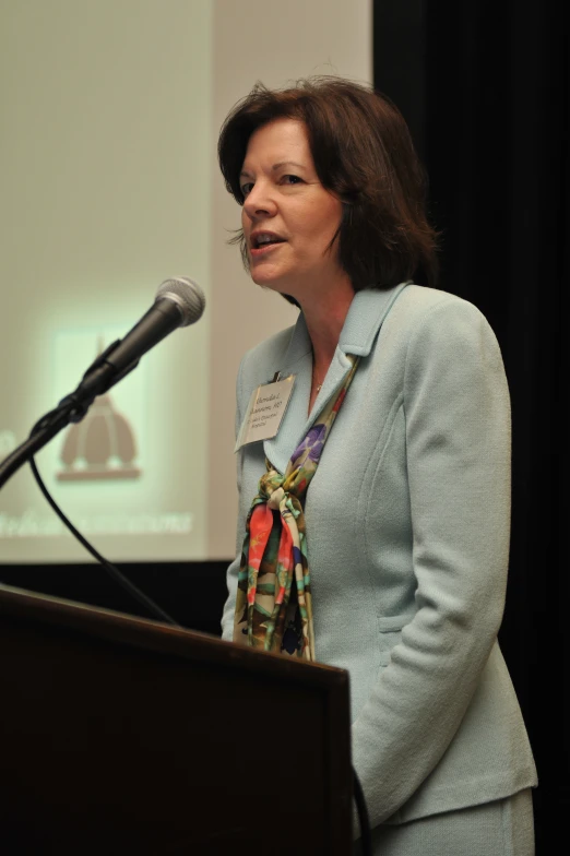 a woman stands in front of a microphone