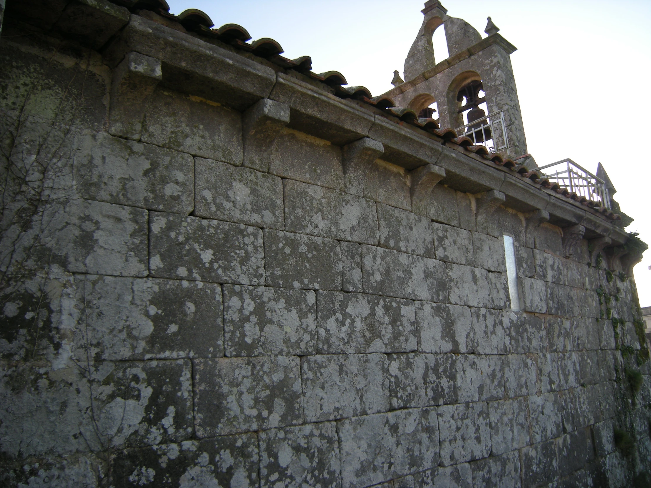 a building with a large stone wall and a steeple with a clock