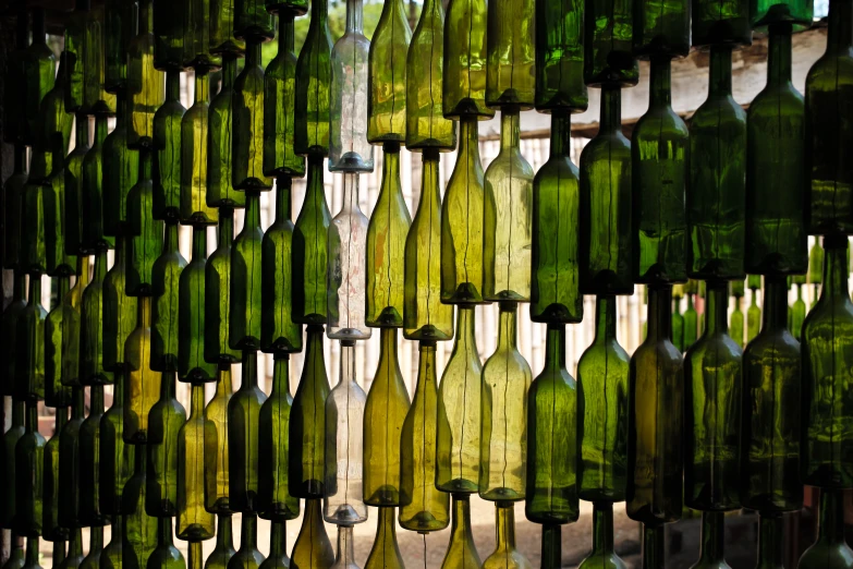 a huge display of green wine bottles in a room