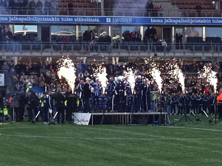 a soccer stadium with a crowd watching the fireworks and smokers