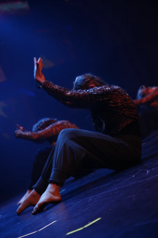 some dancers performing a theatrical act in a darkened room