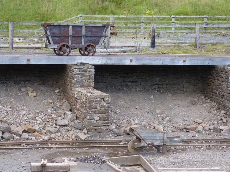 the wagon is parked next to the old bridge