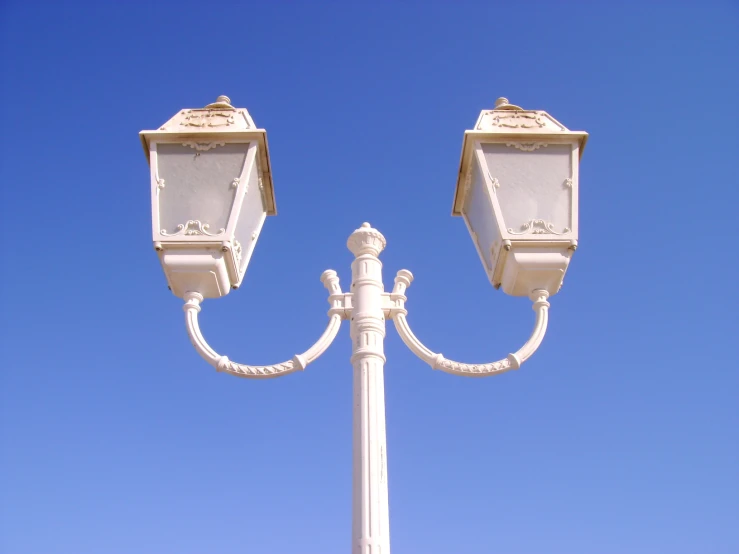 two identical lamp posts in a blue sky