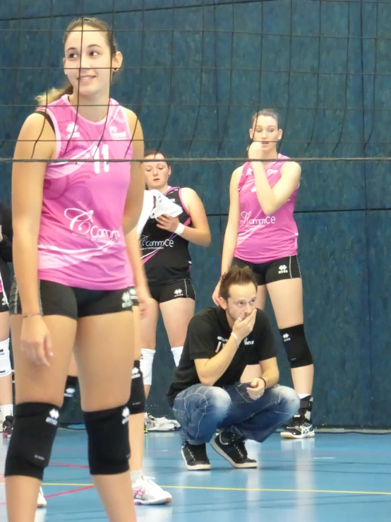 a group of women in volleyball uniform on a court