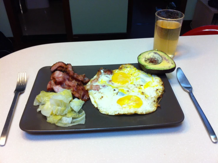 a plate with an avocado and eggs next to a fork