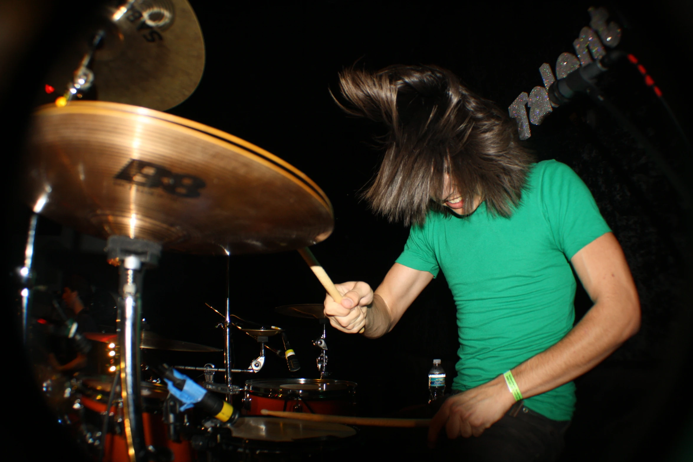 a drummer with a long hair holding a microphone