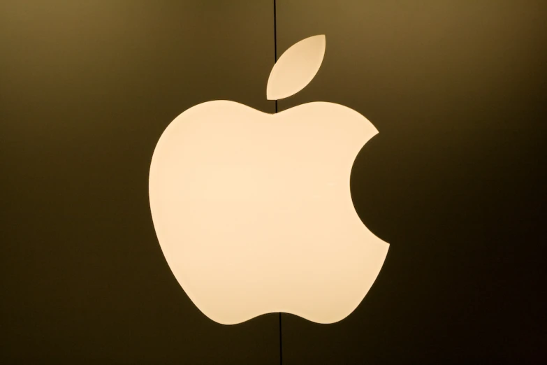 the apple logo is shown against a dark wall