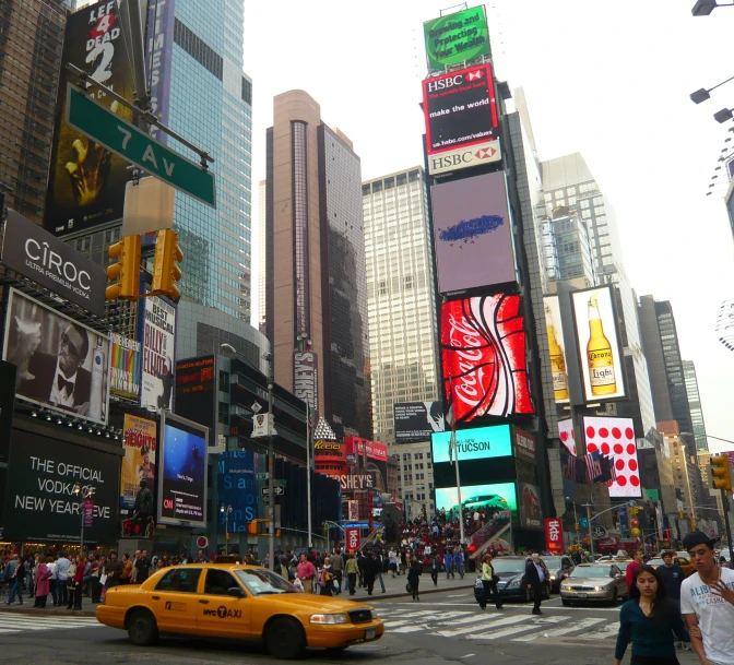 large neon signs at the intersection of a busy city street