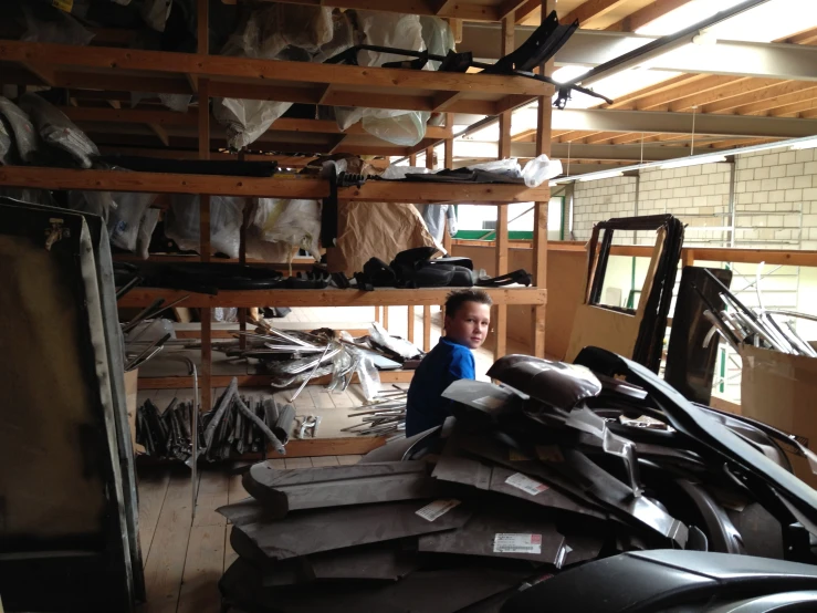 a child sits on the floor of a cluttered room