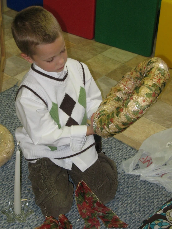 a little boy sits down with his toys