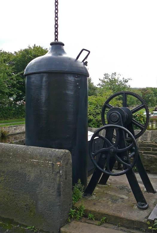 a black oil tank on top of some steps next to a brick wall