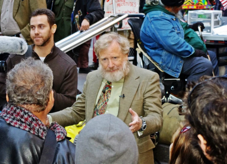 a man in a suit speaking to a group of people