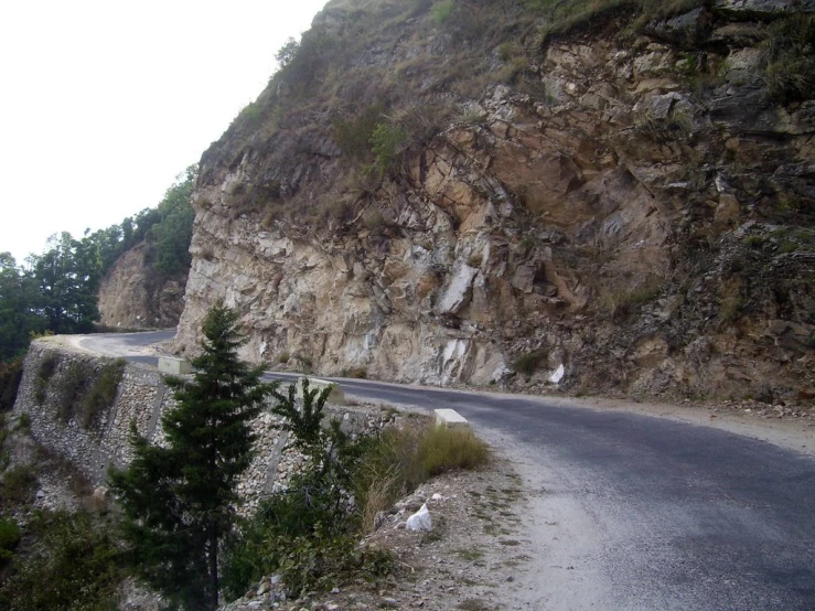 a street on the side of a mountain next to the road