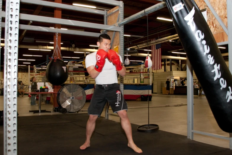 a man in red boxing gloves in a gym