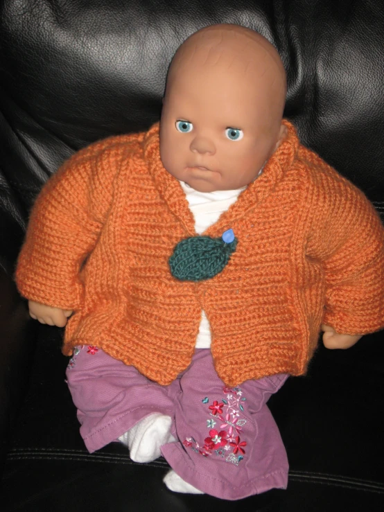 a baby doll wearing a sweater and sweatpants