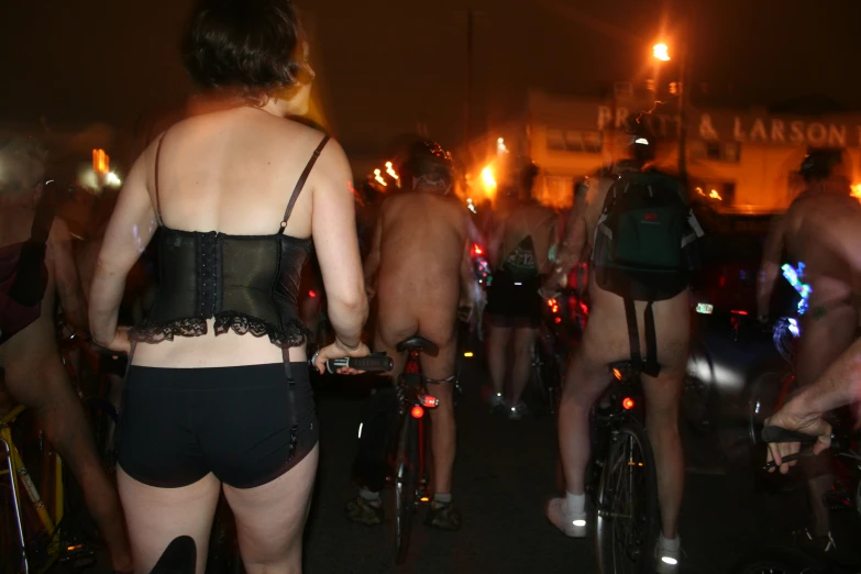 several people wearing underwear walking and riding bicycles