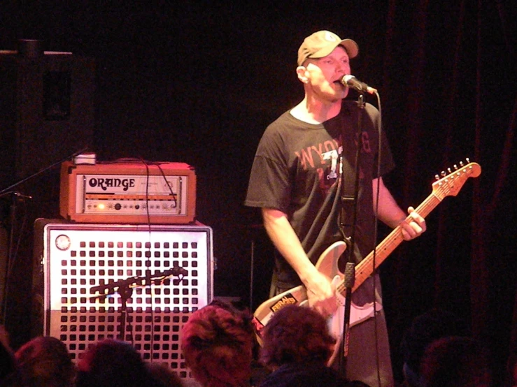 a man singing with a guitar on stage