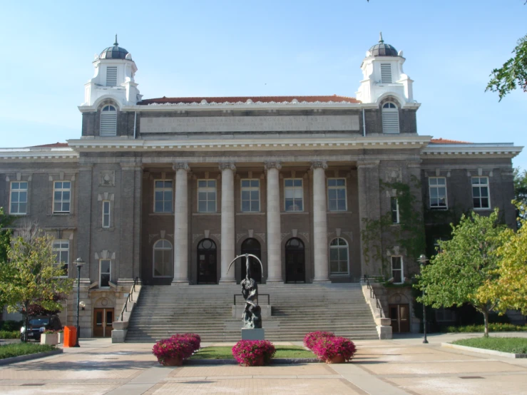 large building with a large flag and two clock towers