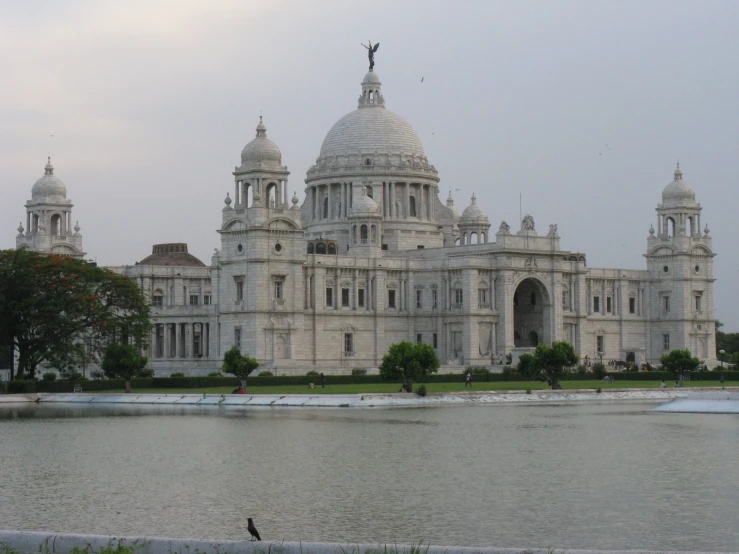 the building is big and white and has many spires on it