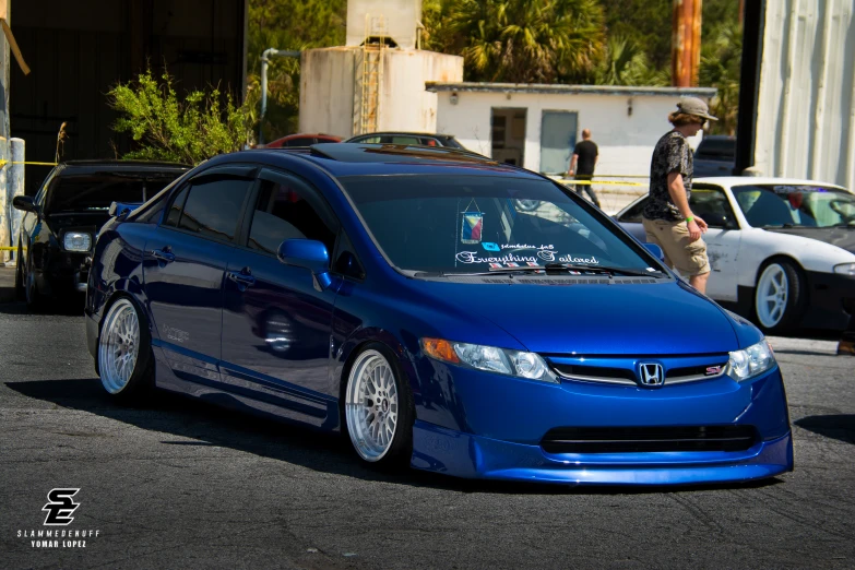 a blue honda civic parked in a parking lot