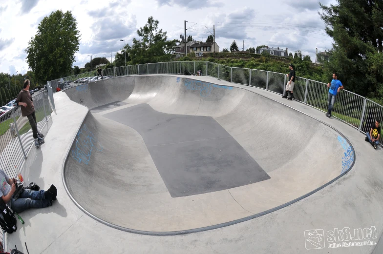 some people on skateboards in a park and a ramp