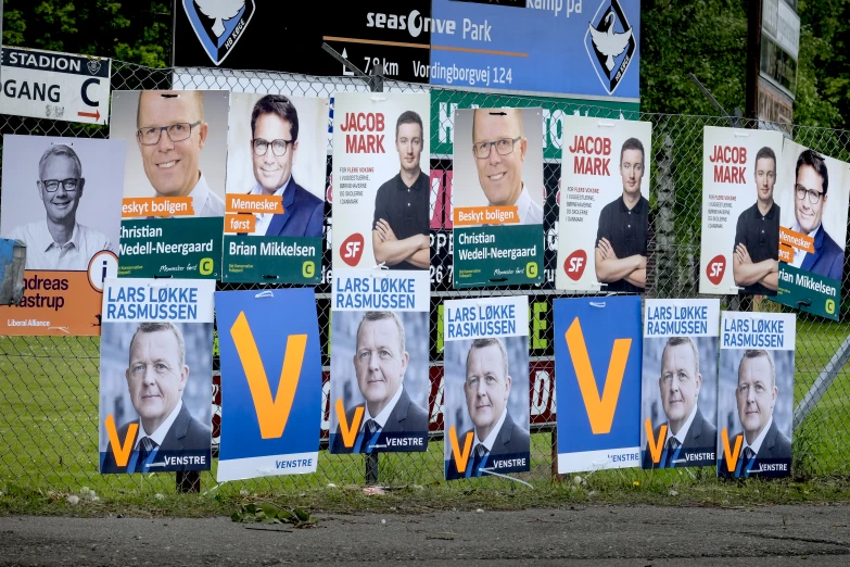many political campaign signs hanging in front of a building