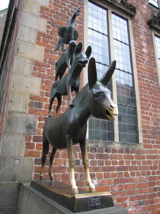 a statue of a donkey has people riding on it