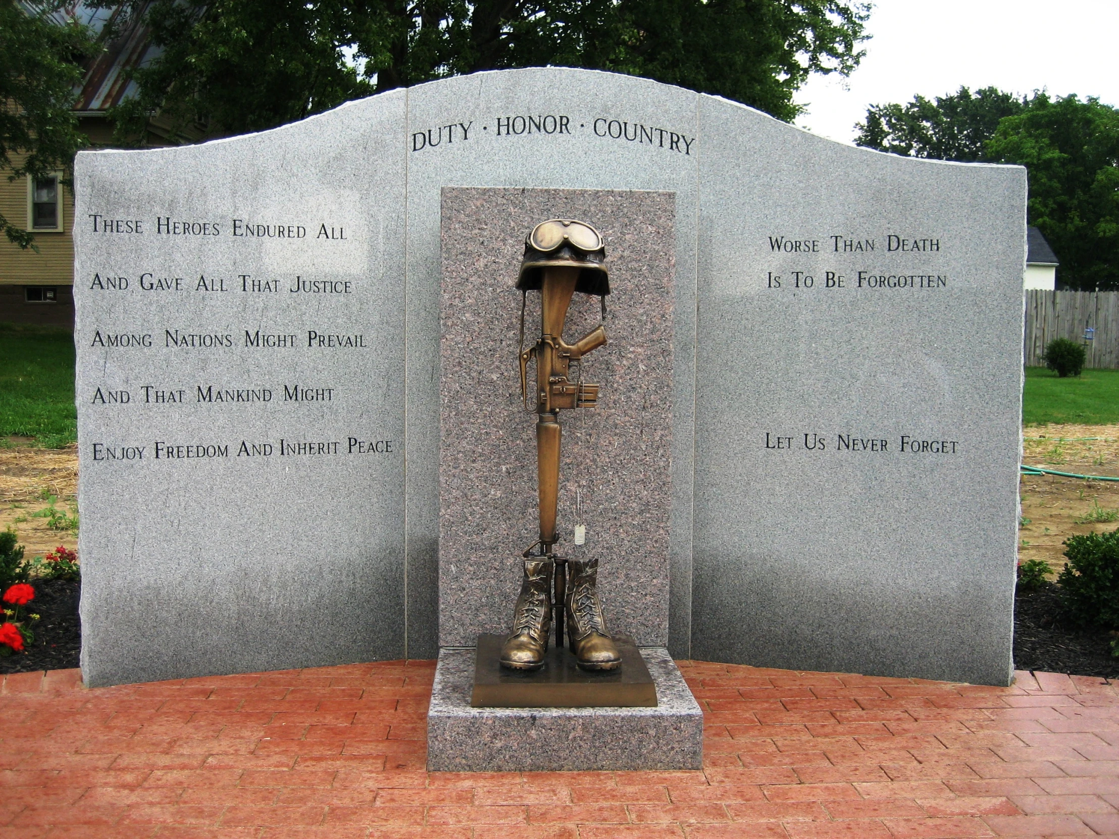 a plaque depicting two soldiers, a kneeling soldier, and names of their comrades