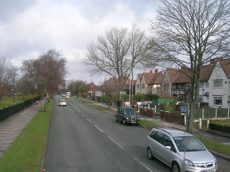 a car driving on the road in front of some houses