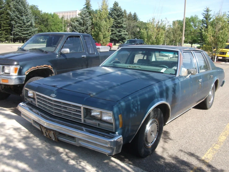 a old, dusty blue car parked in a parking lot