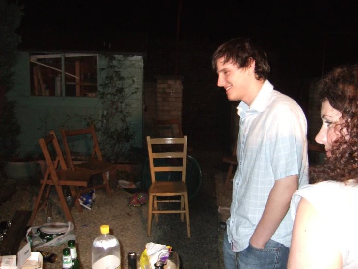 a man and woman standing in front of a table full of bottles