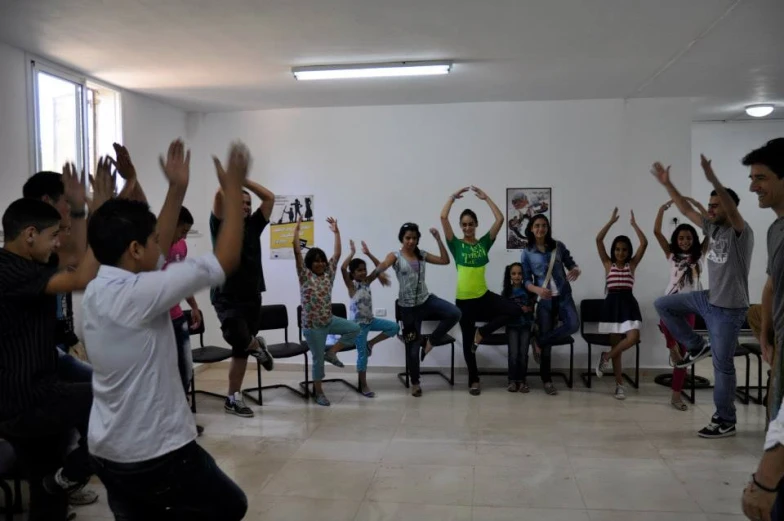 a group of people are in an open area with hands up