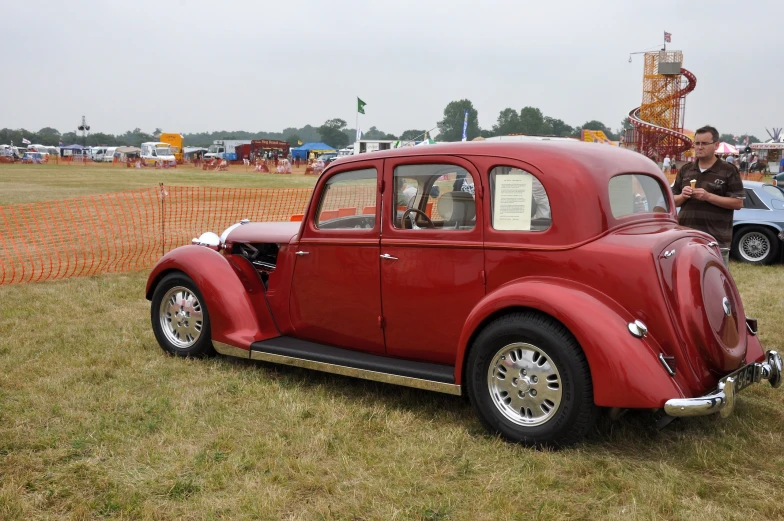 an antique red car with a white stripe in the front