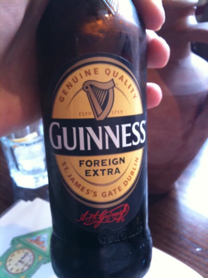 there is a hand holding a guinness beer