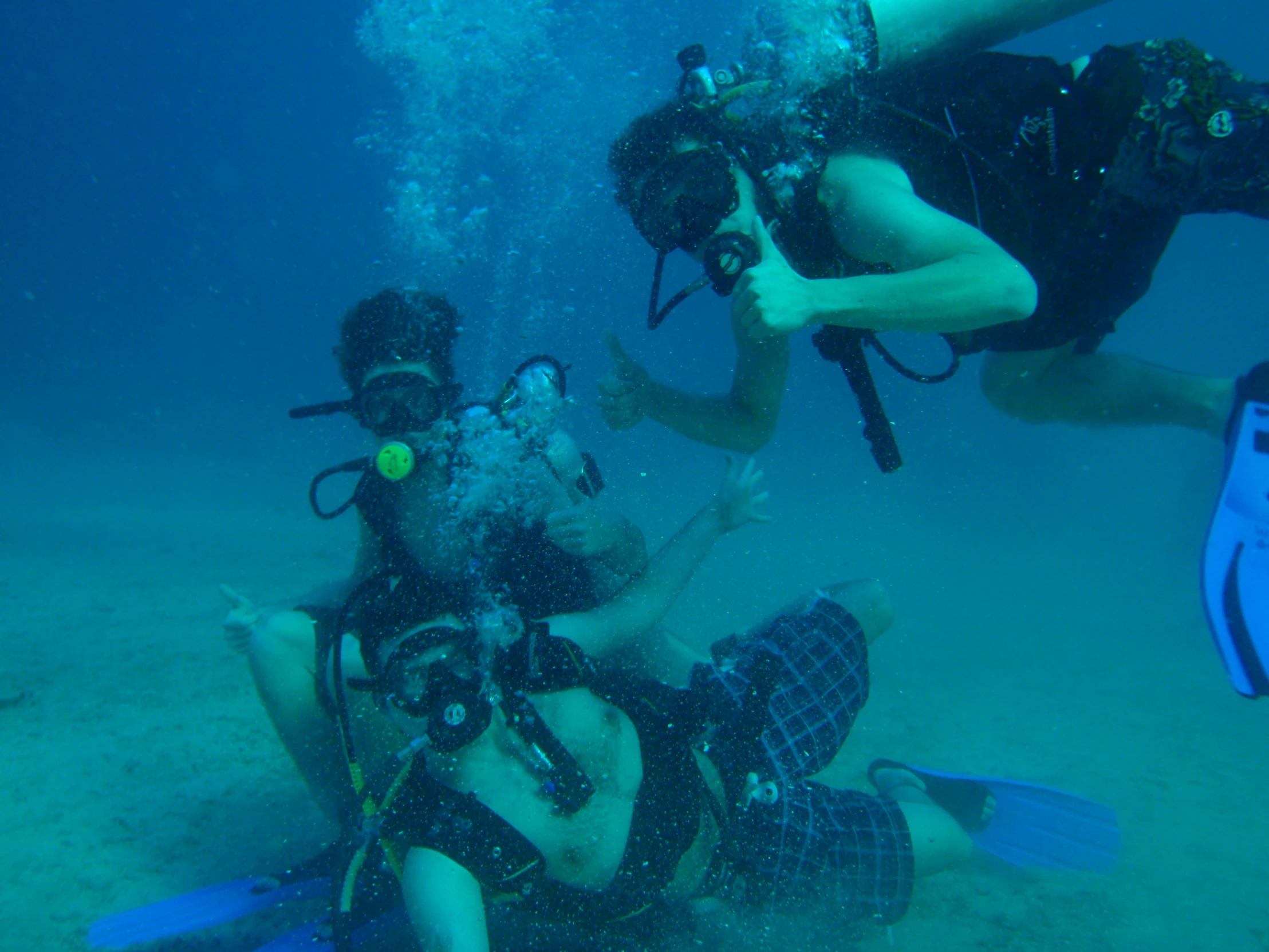 several scuba enthusiasts observing the underwater diver