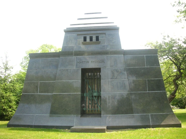 a gray monument with a metal fence in front of it