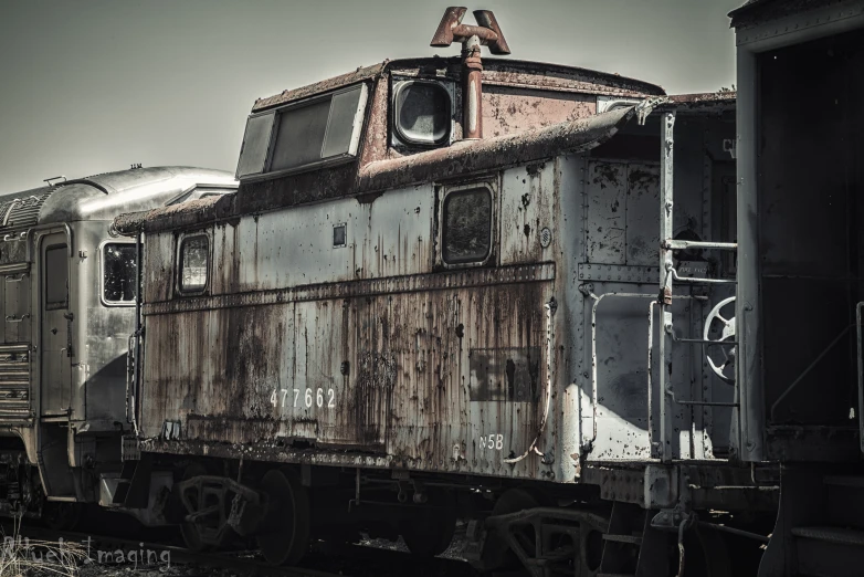an old rusty train car is parked on the tracks