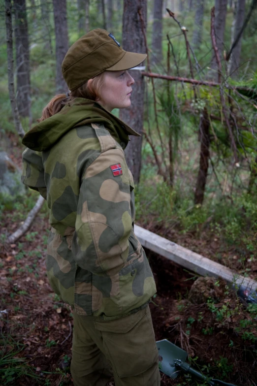 the woman in camouflage is smoking a cigarette